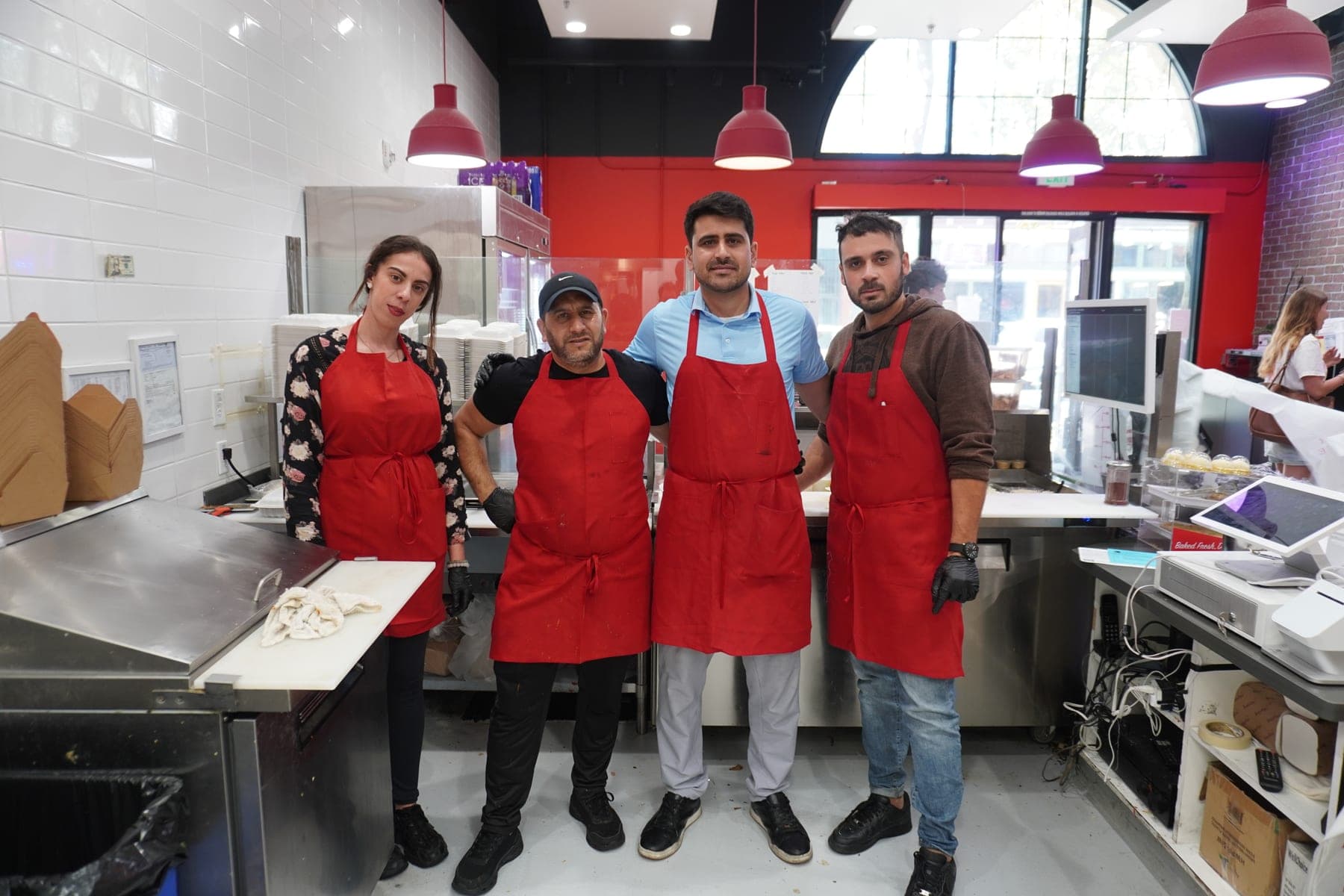 Four of the My-O-My team behind the counter in their red aprons